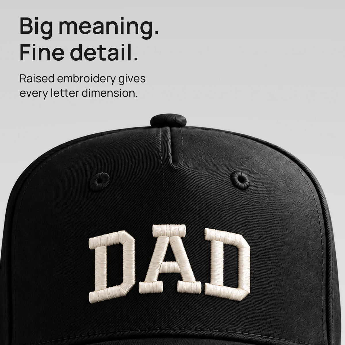 Close detail of raised ivory DAD embroidery on black cotton twill. Big meaning. Fine detail.