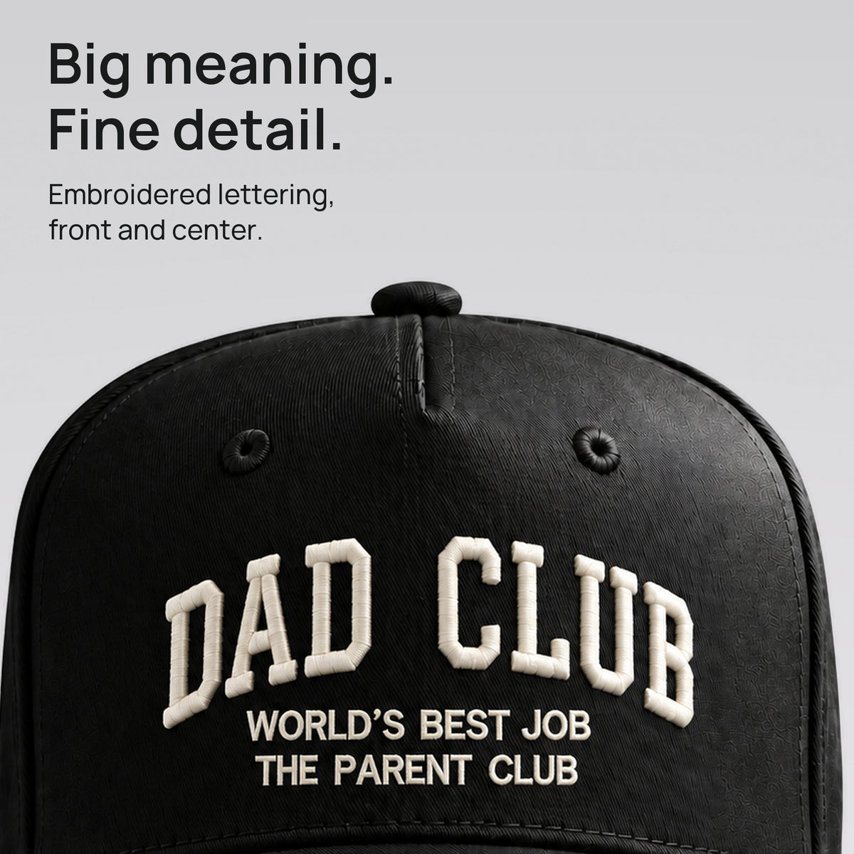Close detail of ivory Dad Club embroidery on black cotton twill. Big meaning. Fine detail.
