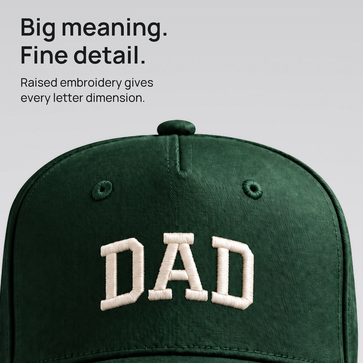 Close detail of raised ivory DAD embroidery on forest green cotton twill. Big meaning. Fine detail.