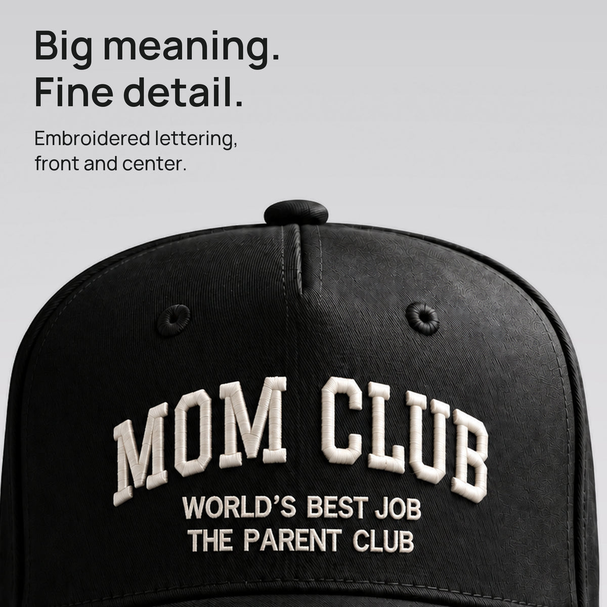 Close detail of the ivory Mom Club embroidery on black cotton twill. Big meaning. Fine detail.